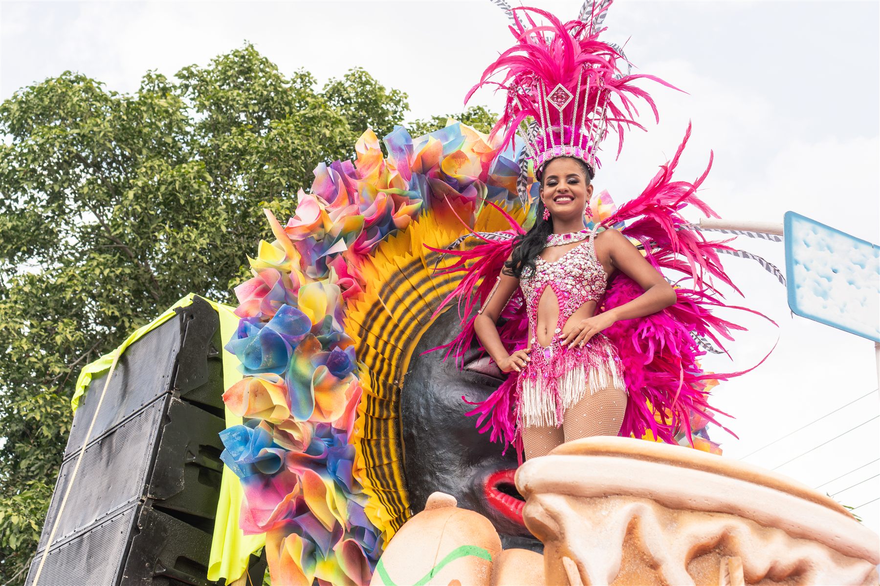 Carnival masqueraders in bright feathers moving on the road.